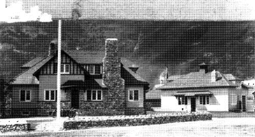 General view of the RCMP detachment building (left) and Garage\Stable (right)showing its rustic style with Tudor-Revival motifs and very good quality craftsmanship and materials.; Parks Canada Agency / Agence Parcs Canada, n.d.