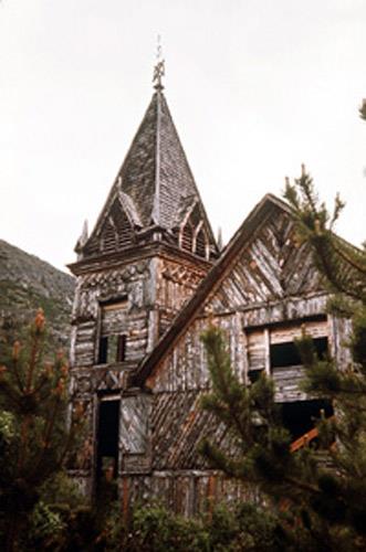 Exterior view of St. Andrew's Presbyterian Church, showing its varied texture and colour created by the use of short lengths of split slabs (bark retained) set in several courses and placed in varying patterns, 1971.; Parks Canada Agency/Agence Parcs Canada, 1971.