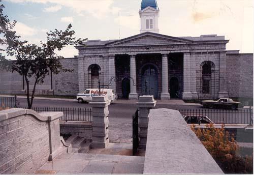 Front facade of the North Lodge building showing the building’s simple neo-classical form and massing, which consist of a symmetrical rectilinear plan.; Parks Canada Agency / Agence Parcs Canada, n.d.