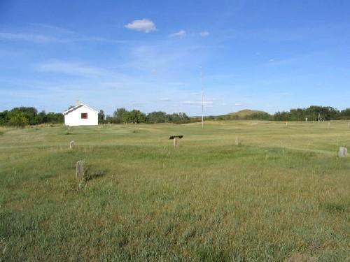 View north at reconstructed barracks with cellar depressions of former buildings in foreground, 2004.; Government of Saskatchewan, Marvin Thomas, 2004.