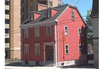 Story-Wilson House, Side elevation showing truncated gable roof and large apartmetn in backgound, Halifax, Nova Scotia, 1997.; HRM Planning and Development Services, Heritage Property Program, 1997.