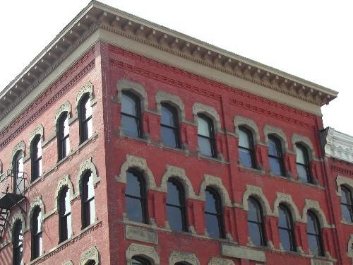 This photograph shows the heavily bracketed cornice and the Roman and pointed segmented arch windows, 2004; City of Saint John