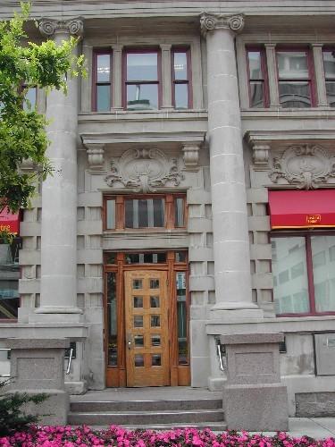 This photograph shows the entrance to the bank, large corinthian columns, and brickwork, 2004; City of Saint John