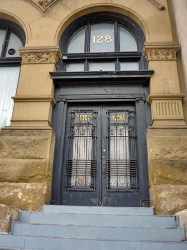 Detail view of the Union Bank Building showing the Romanesque arches on the first floor containing windows and an offset entrance, 2011.; Parks Canada | Parcs Canada, M. Therrien, 2011.