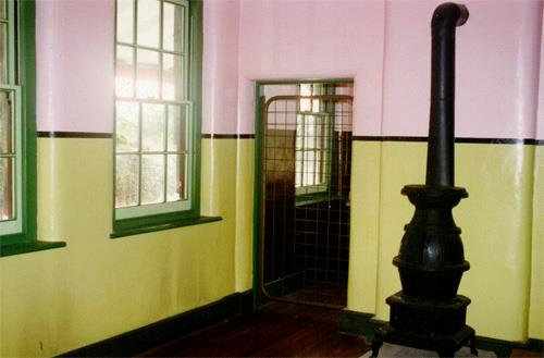 Interior view of the Guardhouse depicting the living room looking beyond into the kitchen.; Agence Parcs Canada / Parks Canada Agency, J. Mattie, 1997.