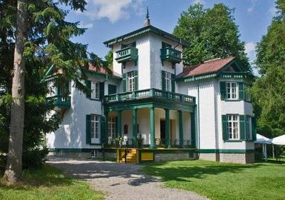 General view of Bellevue House, showing its elaborate detailing of scalloped eave fringe, window shutters, balcony canopy, brackets and balustrades, spoke-shaped verandah rails and tower finials, 2009.; Parks Canada Agency / Agence Parcs Canada, André Guindon, 2009.