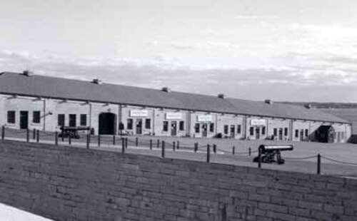 General view of the Commissariat Stores / Reverse Fire Chamber East, showing the long limestone ashlar shot-proof wallcut exterior stone wall, 1996.; Parks Canada | Parcs Canada, 1996.