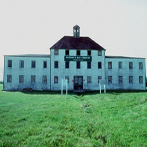 General view of York Factory, showing the Depot building in its rectangular three storey main block with steep hipped roof and conical cupola flanked by two-storey sections under low-hipped roofs which continue to form a central courtyard, its dominant sc; Parks Canada Agency/Agence Parcs Canada, H.07.73.02.05(08), 1977.