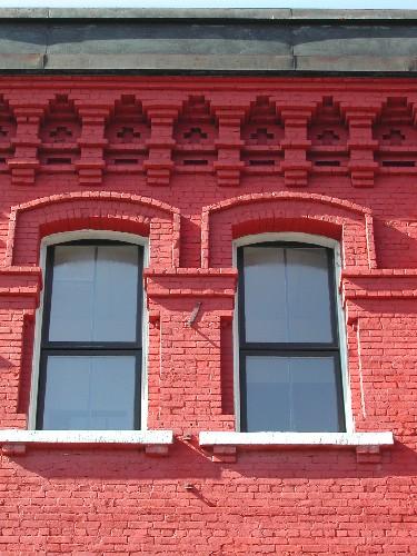 This photograph illustrates the projecting cornice, the decorative brick design, as well as the style and proportion of the windows. 2004; City of Saint John