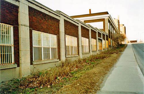 Side view of the south elevation of the Former NCC Building showing the concrete windowsills, the moulded cornice of the two-storey structure and the concrete coping of the one-storey section, 1997.; Parks Canada Agency / Agence Parcs Canada, R. Goodspeed, 1997.