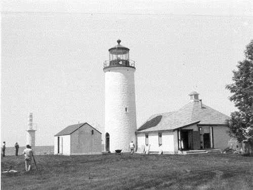 View of the Nine Mile Point Lighthouse with surrounding fog alarm buildings, 1989.; Public Works and Government Services Canada / Travaux publics et Services gouvernementaux Canada, Ross Anderson, 1989.