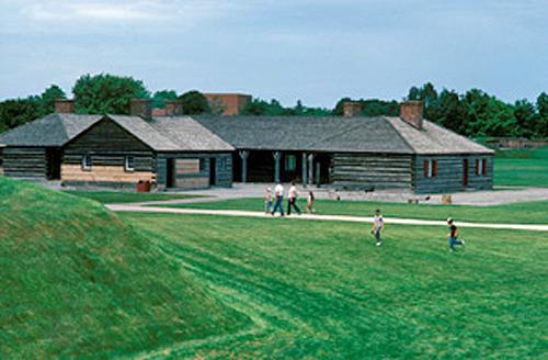 General view of the Officers' Quarters showing the exterior walls constructed of squared logs with dovetailed corners, clad with horizontal clapboard, 1985.; Parks Canada Agency / Agence Parcs Canada, B. Morin, 1985.