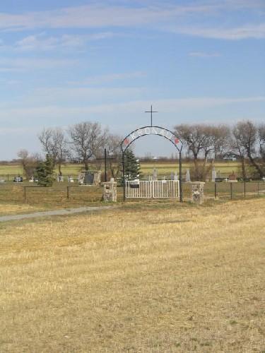 View northeast showing gate, fence, memorial cairn and wooden cross, 2005.; Government of Saskatchewan, Marvin Thomas, 2005.