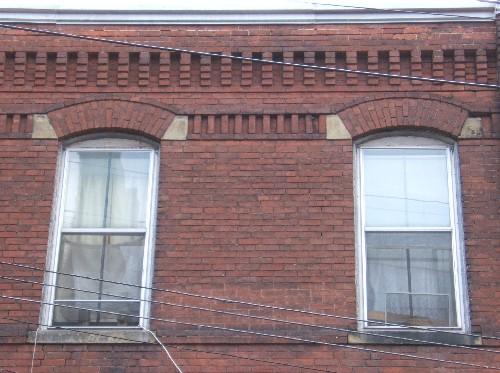 This image provides a view of the segmented arched openings encasing vertical sliding, 2/2, wood windows, 2005. ; City of Saint John