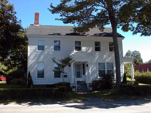 This view of the two storey front façade includes five window or door openings per storey illustrating the neo-classic style.; PNB 2004