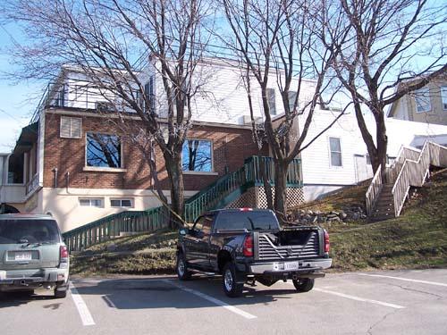 The south facade of the Praga Hotel and the stairway leading to the rooms accessible from the roof of the restaurant. This photo was taken from the parking lot of the Praga Hotel.; Town of Edmunston