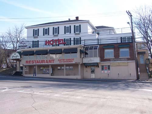Front view of the Praga Hotel. Visible are the facade and the side stairway leading to the upper rooms.; Town of Edmunston