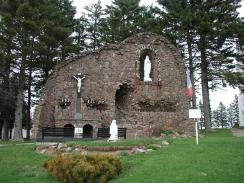 This photo, taken from the front, illustrate the character-defining elements of the Grotto, in particular, Saint Bernadette Soubirous kneeling in front of the Virgin Mary.; Gérard LeBlanc