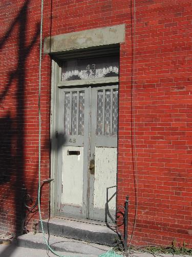 This photograph shows the wooden door with transom window, 2004 ; City of Saint John
