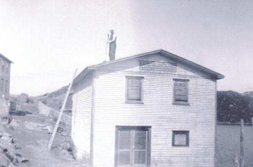 Historic image of Mr. Bill Wakeham tarring the roof of the sawmill while it was in its first location in Petite Forte.  Photo pre 1940.; HFNL/ 2006
