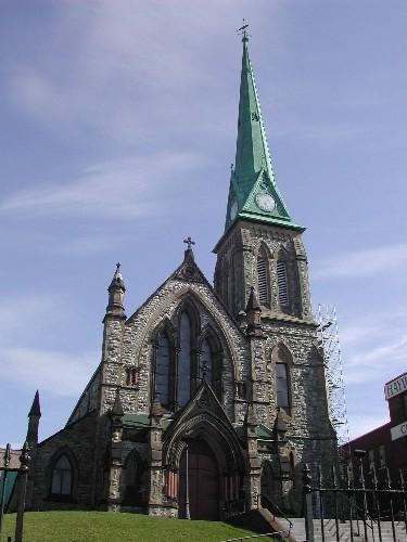 This photograph shows this grand church and its towering presense, as well as its numerous gothic pinnacles, windows, entrance, clock tower and spire, 2004; City of Saint John