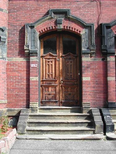 This photograph shows the elaborate entrance and prominent wooden door, 2004; City of Saint John