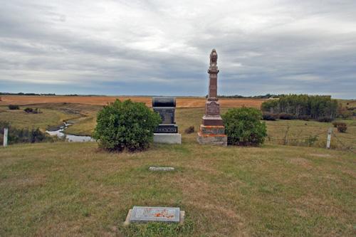 Contextual view, from the east, of the Thomas Greenway Cemetery, Crystal City, 2006. Thomas Greenway's modest in-ground marker lies between the grand stones at the back of the cemetery and the marker for his wife in the foreground.; Historic Resources Branch, Manitoba Culture, Heritage and Tourism, 2006