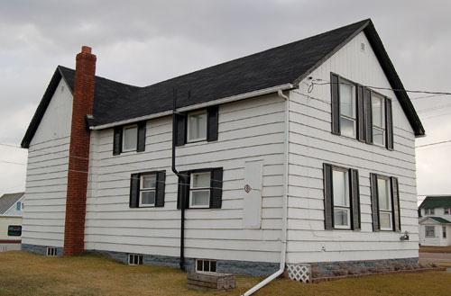 View of the north side - The original Harshman Boarding House is the right side of this residence in this image; Village of Cap-Pelé