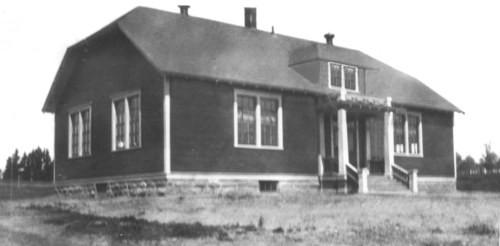 Historic photo of the school, taken from the southeast, showing the double windows for each classroom and the attic.; Memramcook Valley Historical Society