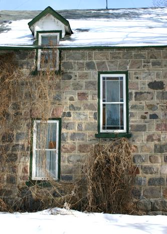 View of the granite fieldstone walls and stained glass window detail, on the west elevation, of the McElroy House, Morden, 2005; Historic Resources Branch, Manitoba Culture, Heritage and Tourism, 2005