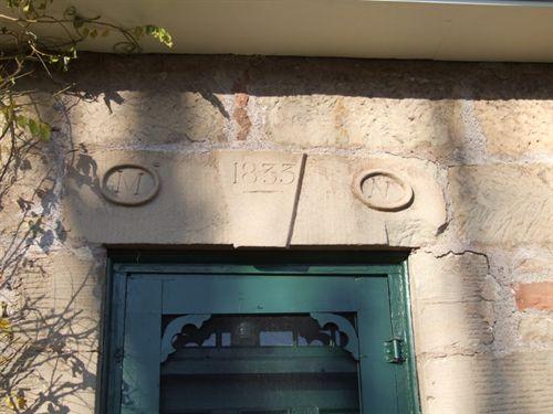 Front entrance with "1833" and "M" and "N" in stone above the door. "M" and "N" for "Murdock Nicolson," the original owner and "1833" for the year the house was built. Stone House, Lower Gulf Shore, Nova Scotia, 2006.

; Front elevation, Stone House, Lower Gulf Shore, Nova Scotia, 2006.

Heritage Division, NS Dept. of Tourism, Culture and Heritage, 2006.