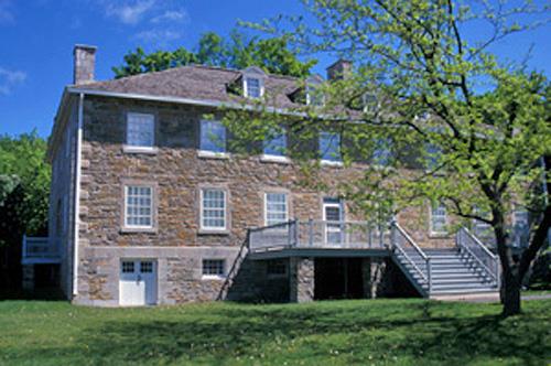 General view of the Carillon Barracks showing the simpler square-headed south door with a gallery, 2003.; Parks Canada Agency / Agence Parcs Canada, E. Le Bel, 2003.