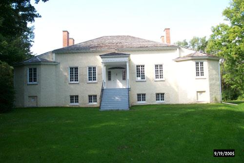General view showing the rectangular massing of the single storey main block with balanced subsidiary wings set high on a foundation.; Parks Canada Agency / Agence Parcs Canada