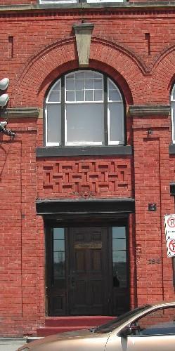 This photograph shows one of the entrances below a roman arch window, 2005; City of Saint John