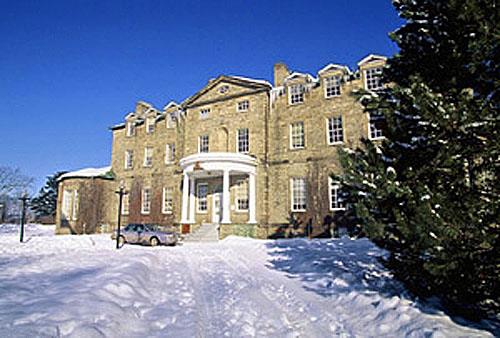 General view of the Old Government House National Historic Site of Canada showing the pedimented projecting frontispiece with semi-circular portico over the main entry, 1995.; Parks Canada Agency / Agence Parcs Canada, J. Butterill, 1995.