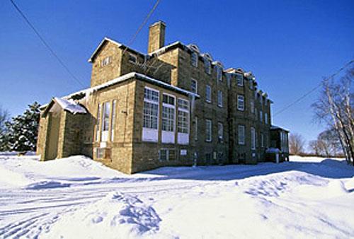 General view of the rear of the Old Government House National Historic Site of Canada showing a central full-height bay, 1995.; Parks Canada Agency / Agence Parcs Canada, J. 	Butterill, 1995.