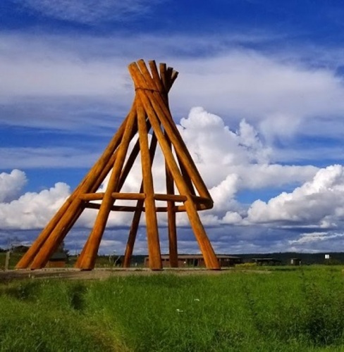 Large wooden teepee at Ehdaa; Madison Pilling, Liidlii Kue First Nation | Première Nation Liidlii Kue