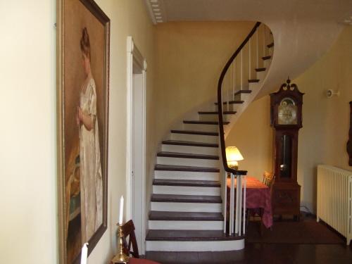 This photograph shows the spiral staircase and the portrait of Mrs. Ross in the foreground to the left, 2007.; Town of St. Andrews