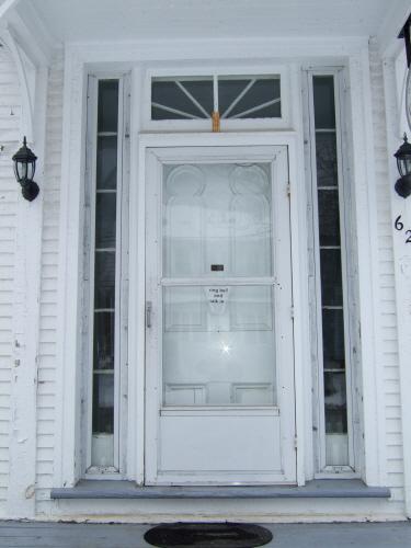 This photograph illustrates the transom window, sidelights and ornate wood door, 2007; Town of St. Andrews