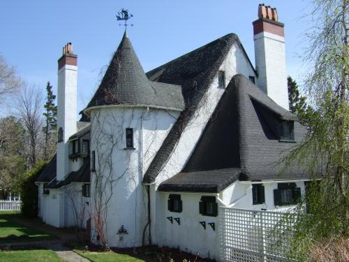 This photograph shows the contextual view of the building and illustrates the turret, tall stucco and brick chimneys, and immitation thatched roof, 2007; Town of St. Andrews