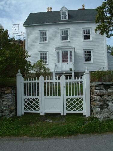 View of front facade of Lakeview, Brigus, NL showing the wooden gate, stone wall and Brigus porch.; © HFNL 2007