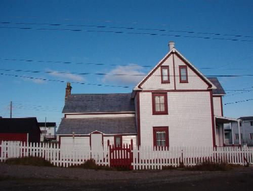 View of Brett Property Municipal Heritage Site, Joe Batt's Arm, showing fence, left side of house and outbuilding at rear, 2006/11; L Maynard, HFNL, 2007