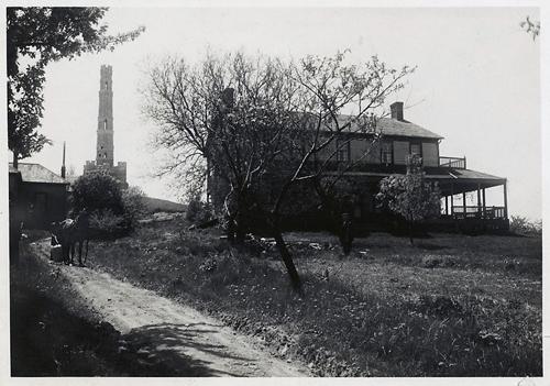 View of the monument with the Gage House in the foreground; Hamilton Public Library, Special Collections