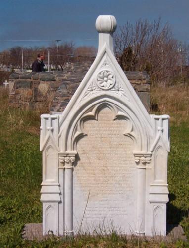 Photo view of Father Troy marble headstone with stone cross in the background, looking west, Old Holy Trinity Parish Cemetery, Torbay Road, Torbay, NL, 2006/05/10; L Maynard, HFNL, 2006