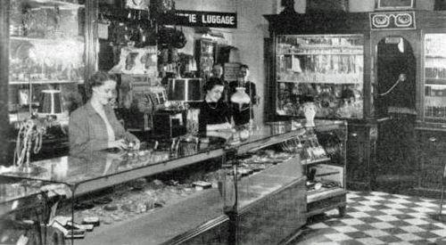 Interior view of Moss Jewellers, Amherst, NS, ca. 1949. Leon Moss can be seen in the background, one of two men standing under the luggage sign.; Courtesy of the Town of Amherst