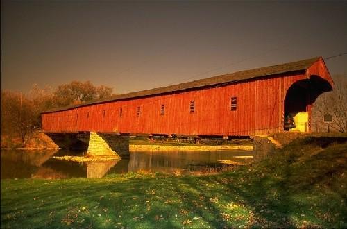 The West Montrose Covered Bridge, viewed from the south bank of the Grand River.; Ontario Tourism Marketing Partnership
