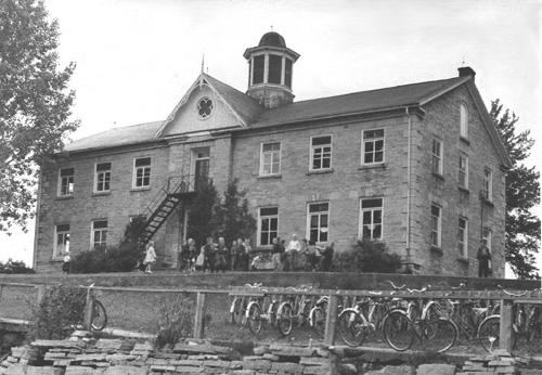 Historic view of the main (south) façade showing school children playing in the yard – c. 1959; Fluke, 1977