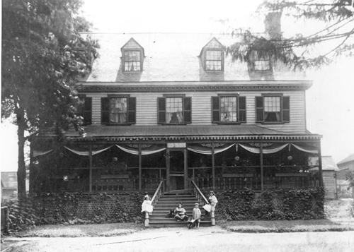 Historic view of the west facade showing one of four verandahs in the building's history c.1911; Hiram Walker Historical Museum, 1979