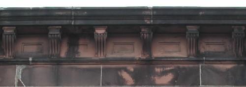 This image shows the stone cornice supported by decorative brackets, 2005.; City of Saint John
