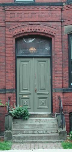 This image shows the projected, segmented arched entrance and transom window over the wooden doors, 2005.  ; City of Saint John